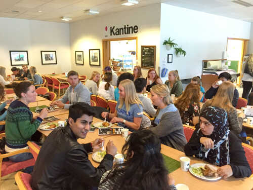 Bilde fra en kantine, mange er samlet til måltid 