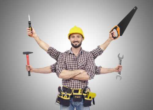 A worker with a plaid shirt and a yellow helper. He has a carpenter's belt around his waist with lot