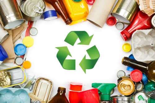 3 green arrows in a circle that symbolize recycling and different types of garbage around
