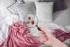Magnifying glass looking for bed bugs in bed