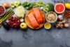 spices, vegetables and salmon fillet on a black stone kitchen bench