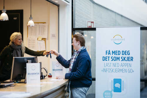 Student som får overlevert nøklene i skranken 