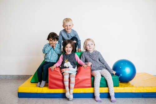 Four happy children playing at a kindergarten.